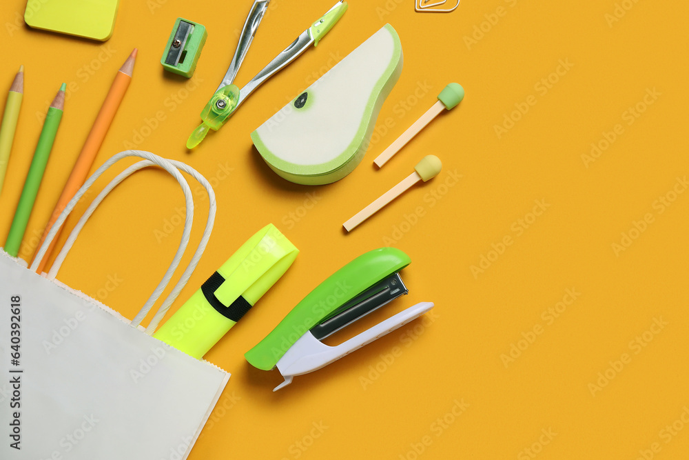 Composition with paper bag and different stationery on color background