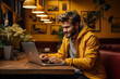 © Wan Cardoso - Homen na empresa com laptop sentado, fundo amarelo