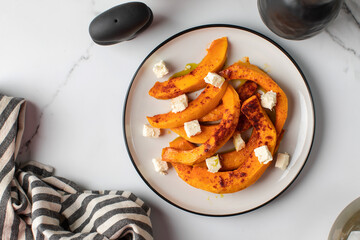 Wall Mural - Baked pumpkin slices with spices and cubes of feta cheese. Pumpkin dishes.