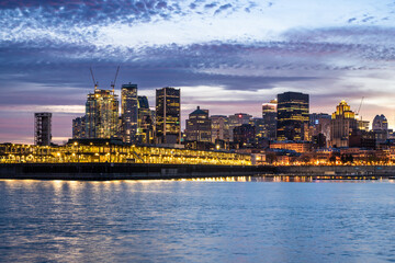 Wall Mural - Montreal Canada city skyline at sunset with buildings and river in view.