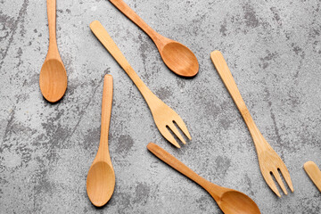 Wooden spoons and forks on grey background