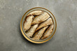 Sprats in tin can on grey textured table, top view