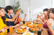 © CandyRetriever  - Group of Young Asian man and woman friends having dinner party eating food and drinking soft drink together at home. Happy people enjoy and fun meeting celebration party on festival holiday vacation.
