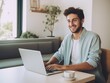 © FreyrStock - joyful relaxed smiling young man using laptop