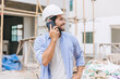 © Quality Stock Arts - happy foreman builder using smart phone calling business contact in construction site. construction engineer or architect with modern connection technology device.real estate investor