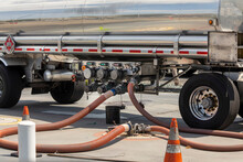 Gasoline Being Offloaded From A Tanker Truck Into An Underground Storage Tank At A Gas Station