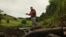 Low-angle Shot Of A Fly Fisherman Casting Into A Small Low River In Scotland