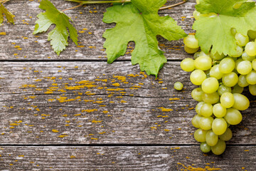 Wall Mural - Grape with vine leaves on wooden table