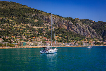 Sticker - Mediterranean Sea and coastline with a beach and a boat in the water in Menton on the French Riviera, South of France on a sunny day