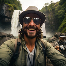 Portrait Of A Man In A Mountain, Handsome Tourist Visiting National Park Taking Selfie Picture In Front Of Waterfall - Traveling Life Style Concept With Happy Man Wearing Hat And Sunglasses Enjoying