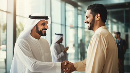 Wall Mural - Emirati businessman in UAE's traditional talking handshake with friend in the office