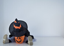 Little Girl Dressed As A Witch Sticking Her Head In Her Halloween Basket, White Background