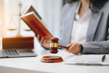 justice and law concept.law theme wooden desk, books, balance. Male judge in a courtroom the gavel,working with digital tablet computer on table.