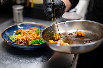 chef cooking Salad with funchoza, shrimp and vegetables