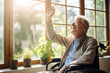 © MNStudio - Cheerful old man in a retirement home. Senior man in a wheelchair laughing happily in a nursing home. Housing facility intended for the elderly people.