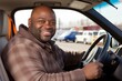 © Yuliia - Portrait happy cheerful African American smiling mature man trucker driving car sitting taxi cab get ready travel. Confidence business long transport delivery passenger driver license driving school