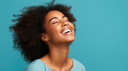 Canvas Print - Young woman laughs against a blue background.