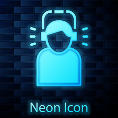 Sticker - Glowing neon Man in headphones icon isolated on brick wall background. Vector