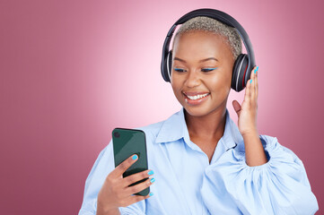 Wall Mural - Music, headphones and black woman with phone in studio for streaming, radio or listen on pink background. Smartphone, app and African lady model with online audio, podcast and earphones for album