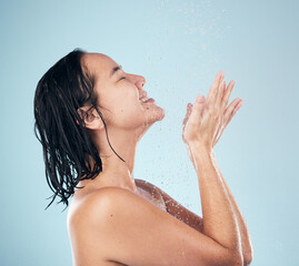 Wall Mural - Skincare, shower and woman smile cleaning in studio isolated on a blue background. Water splash, hygiene and model happy, washing and bathing in wellness, healthy skin beauty of body in bathroom.