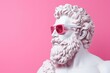 © Владимир Солдатов - Greek sculpture of the god Zeus wearing rose-colored glasses on a pink background.