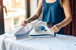 © JKLoma - The housewife is ironing clothes with determination.