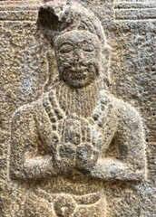 Wall Mural - Bas relief stone carving of ancient historical sculptures carved in the walls of Hindu Temple in Thirumullaivoyal, Tamilnadu. Sculpture of a scholar carved in the stone walls at ancient temple.