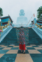 Woman With Open Arms In Front Of Buddha