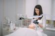 © Anna - Cosmetologist and dermatologist preparing for anti-aging injection for lying woman patient in beauty salon.
