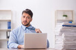 © Elnur - Young male employee and too much work in the office