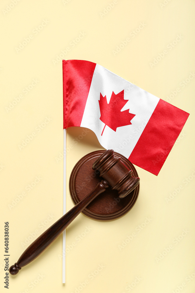 Flag of Canada with judge's gavel on beige background