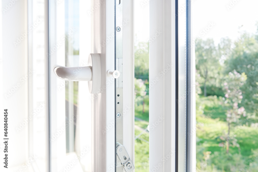PVC window frame open closeup view. Lock window frame detail. Room open window ventilation. Mechanism of white plastic window sash.