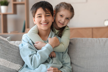 Poster - Little girl hugging her brother at home