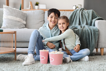 Sticker - Little girl hugging her brother while watching movie at home