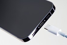 Bottom part of modern smartphone with high speed usb type-c communication port and charging cable. Universal USB type-c charge standard for smartphone. up-to-date technologies for communication.