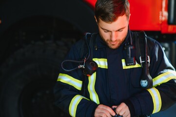 Wall Mural - Photo of fireman with gas mask and helmet near fire engine