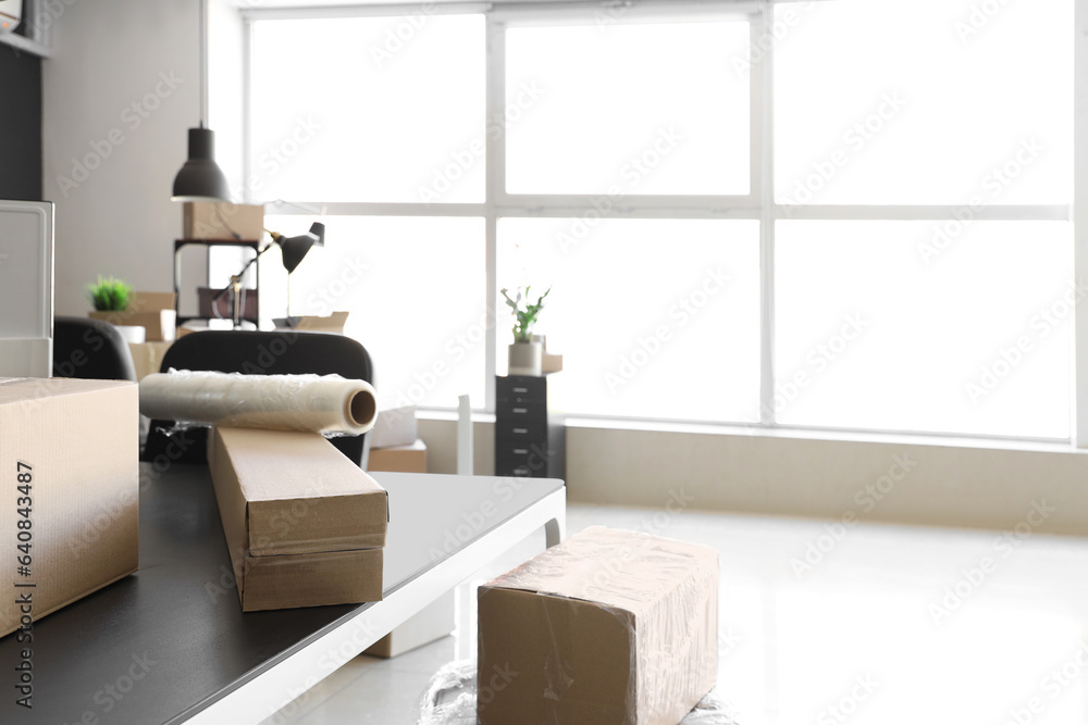 Interior of modern office with cardboard boxes on moving day