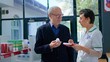 © DC Studio - Elderly man in chemist store asking pharmacist for medical opinion, needing treatment for headache. Certified druggist helping senior client choose best pharmaceutical cure for his pain
