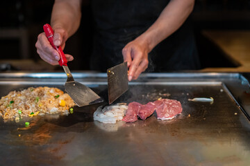 Chef cooking in Japanese teppanyaki restaurant