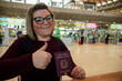 Thumbs up of an Italian female passenger showing her passport at the airport before leave.
