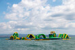 Inflatable bounce castle floating in water. Aqua park for children having fun in water park. Aquapark with attractions in the sea. Popular tourist activity, water sport