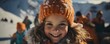 © mandu77 - Smiling girl in orange hat and scarf on background of snow covered mountains