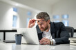 © Volodymyr - Office worker with laptop at office. Ofice employee remote working in modern office. Businessman on remote meeting, working online in offices place. Business man using computer in office.