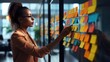 © ANEK - Web designer is working with brainstorming board full of sticky note from colleague