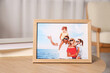 Pleasant memories. Wooden photo frame with family portrait on table indoors, closeup. Space for text