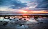 Fototapeta Miasto - Photo of a breathtaking sunset over the ocean on a tranquil beach