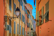 Picturesque old street light, colorful traditional houses with shutters in the background in the old town of Menton, French Riviera, South of France