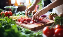 Woman Is Cooking In Home Kitchen. Female Hands Cut Salami, Vegetables, Greens, Tomatoes On Table On Wooden Boards. Ingredients For Preparing Italian Or French Food . Generative AI