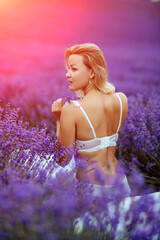 Canvas Print - Woman lavender field. A middle-aged woman sits in a lavender field and enjoys aromatherapy. Aromatherapy concept, lavender oil, photo session in lavender