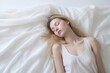 woman sleeping in white sheets, clean and minimalist photo